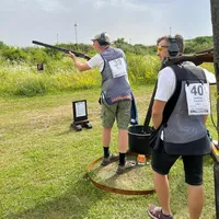 Zwei Schützen am Hang, einer im Ring die Taube abrufend